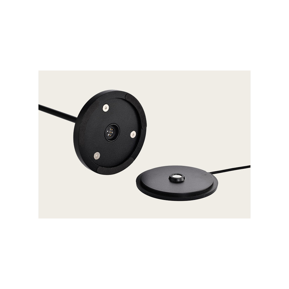 Détail du socle rond noir avec contact central et câble d'alimentation