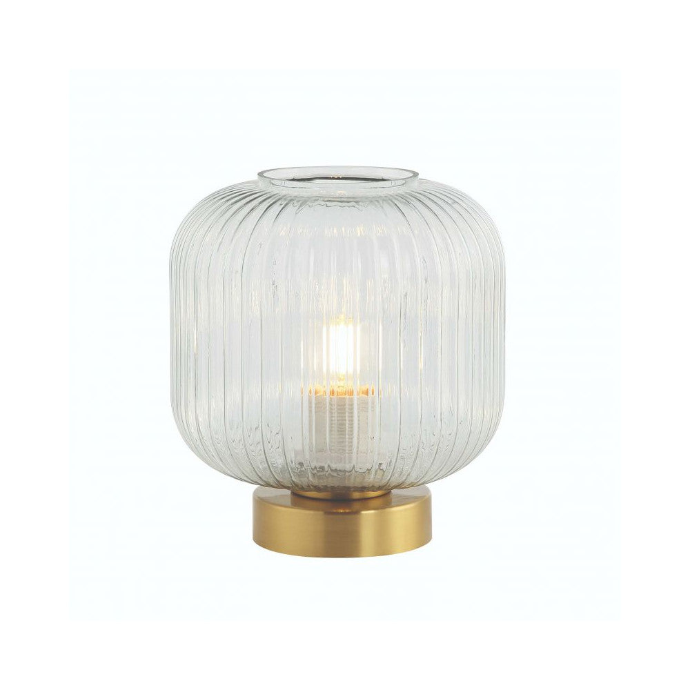 Lampe à poser isolée sur fond blanc, verre cannelé et socle cylindrique en laiton doré
