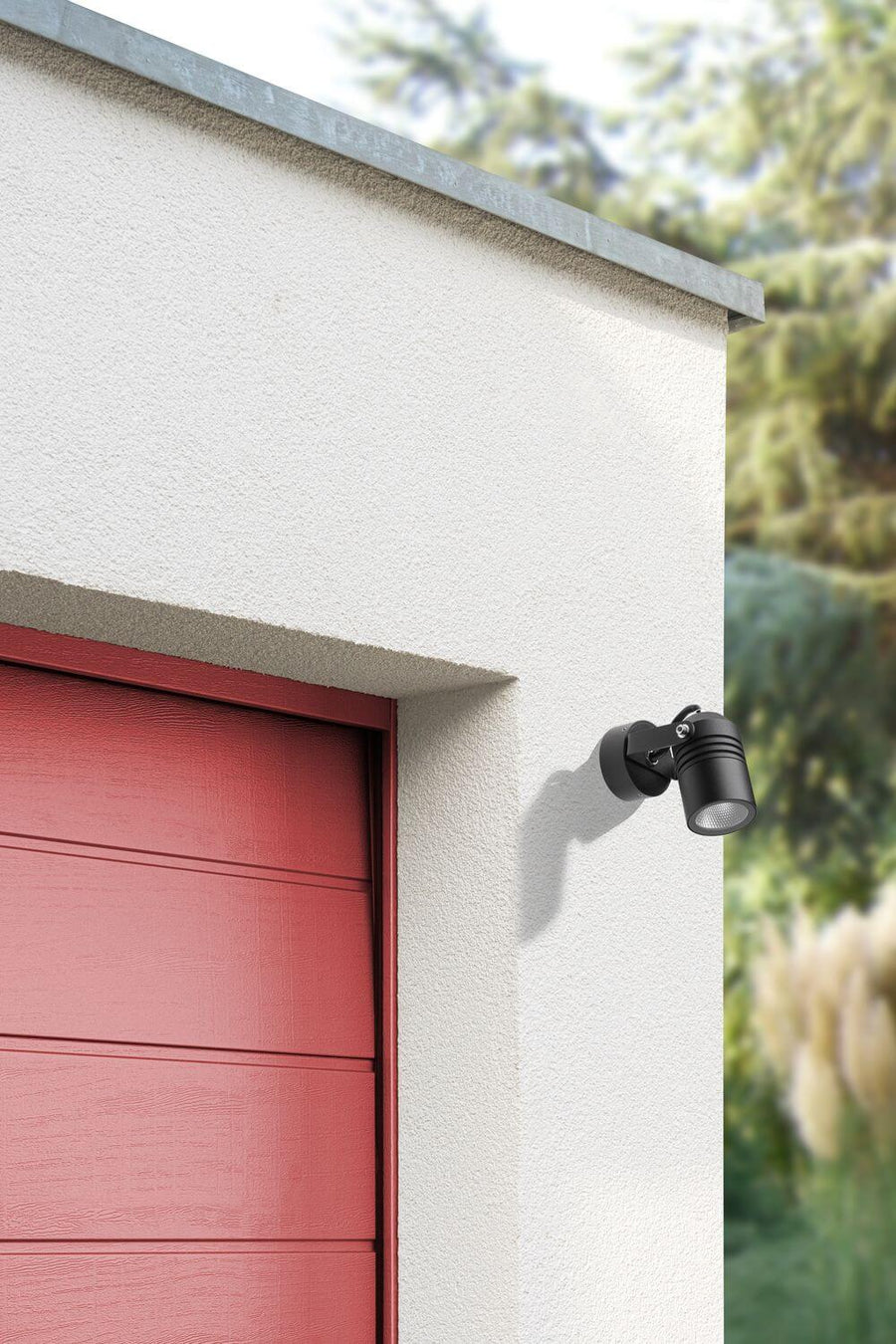 Vue rapprochée du spot mural orientable installé sur une façade extérieure crème