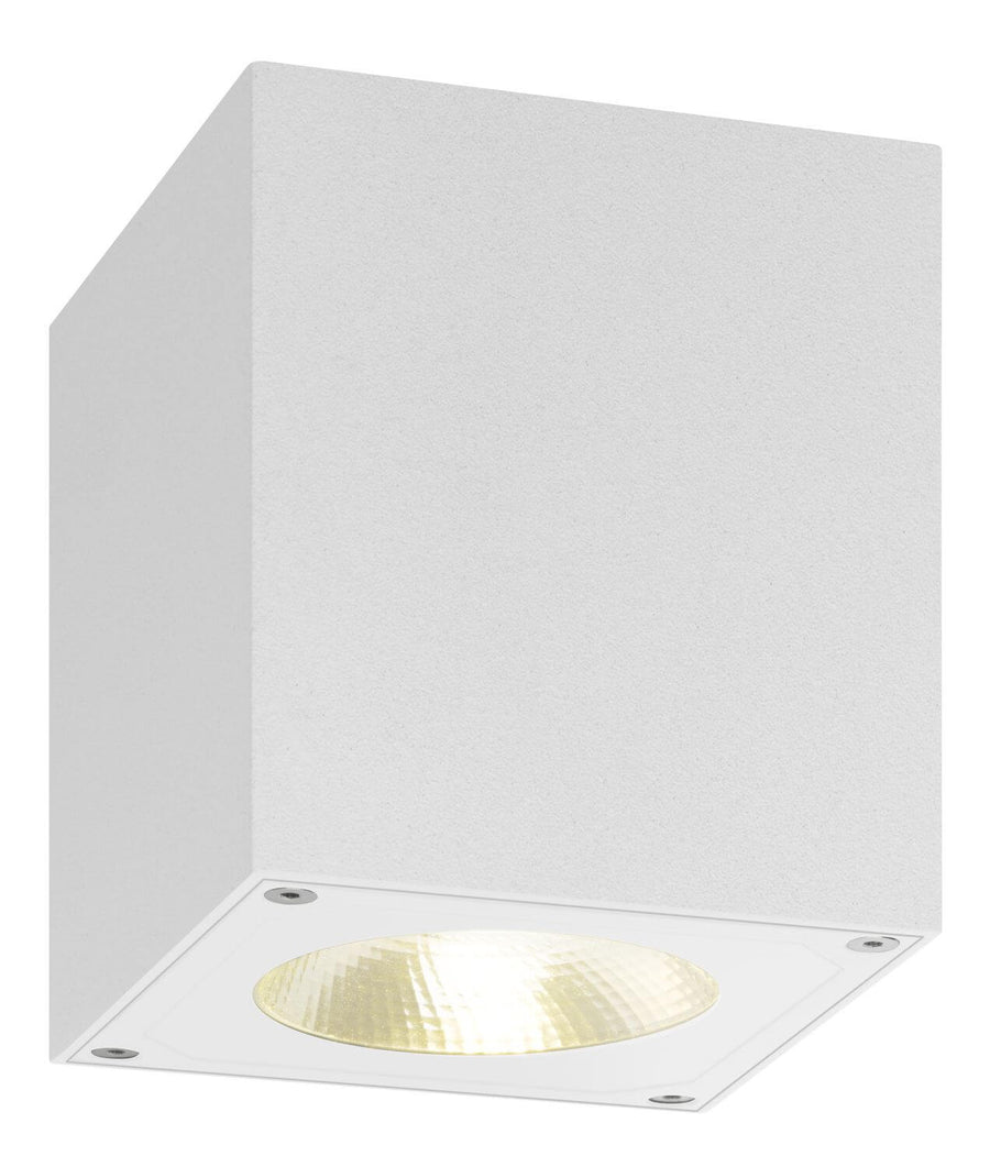 Produit blanc allumé, réflecteur strié diffusant une lumière chaude vers le sol.