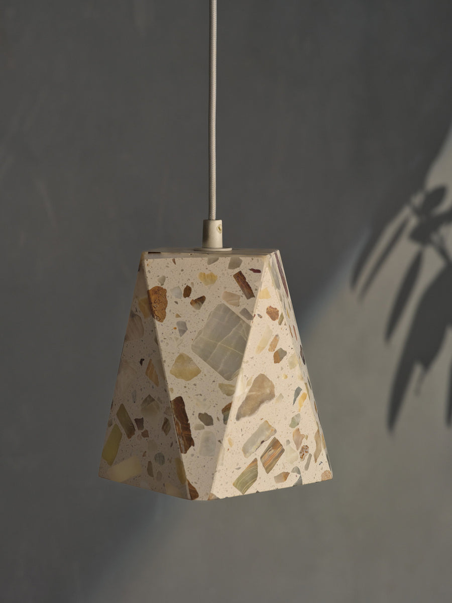 Détail rapproché de l'abat-jour facetté en terrazzo beige