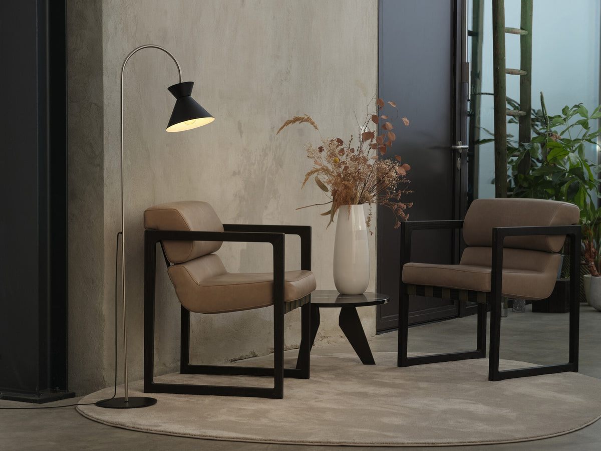 Mise en ambiance : lampadaire allumé entre deux fauteuils et un vase.