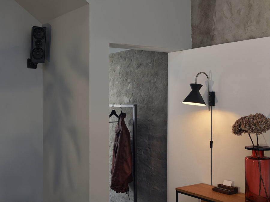 Mise en situation de l'applique allumée dans un couloir décoré, éclairant un mur.