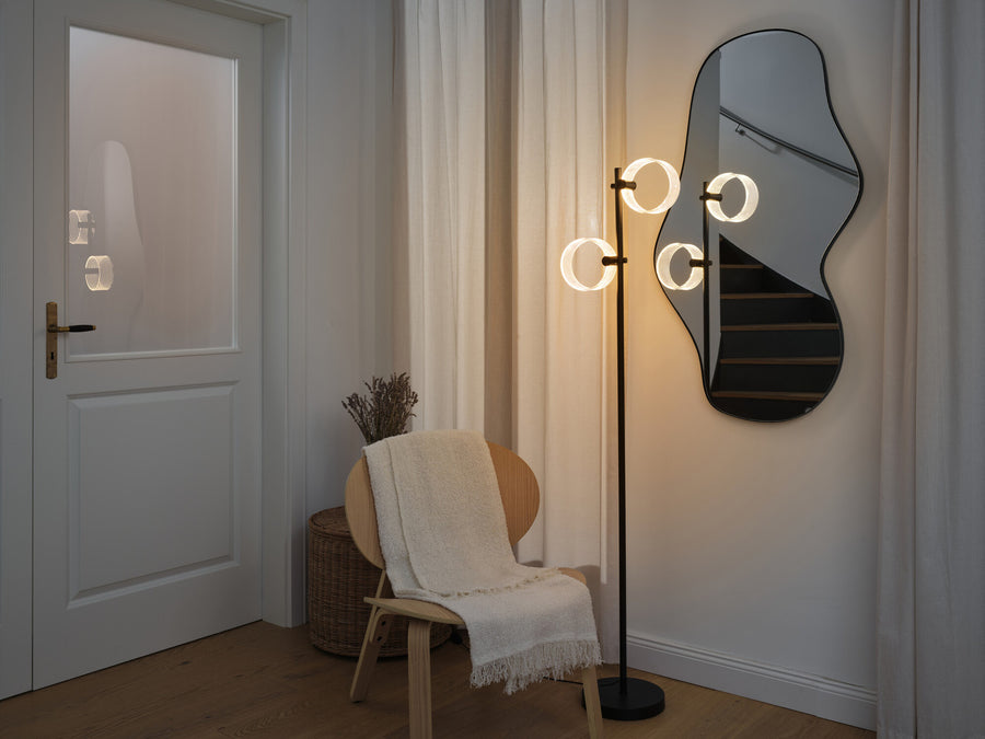 Lampadaire diffusant une lumière chaude dans l'entrée, reflet dans le miroir