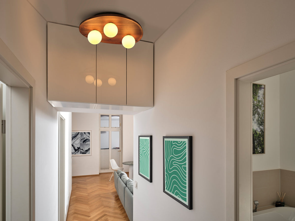 Plafonnier en bois allumé dans un couloir moderne aux murs clairs et parquet.