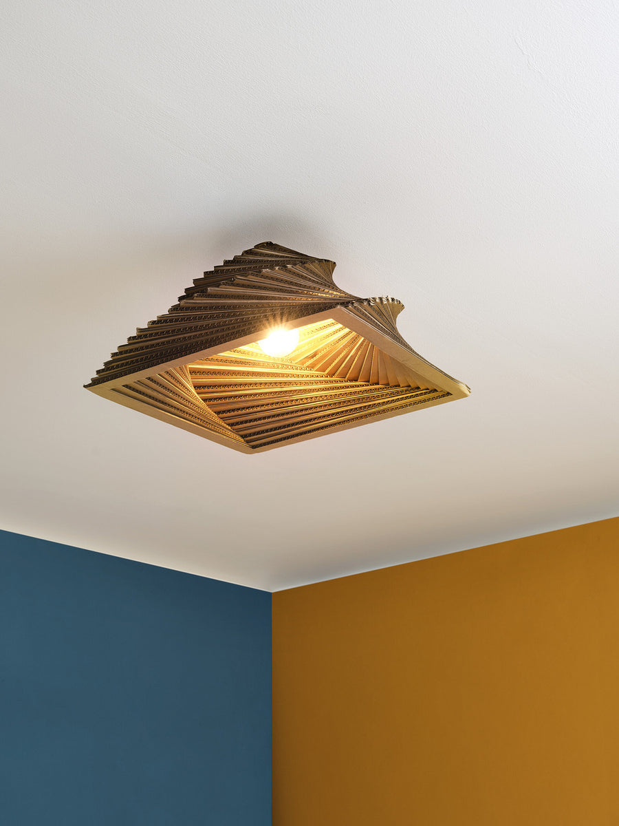 Détail du plafonnier allumé fixé au plafond, lumière chaude et structure alvéolée