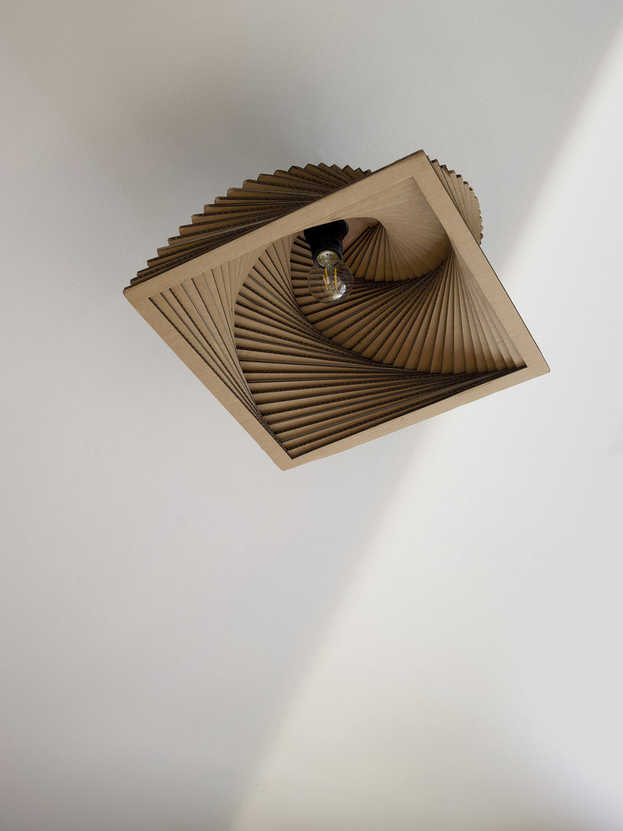 Vue rapprochée de l'intérieur montrant l'ampoule et les plis en carton