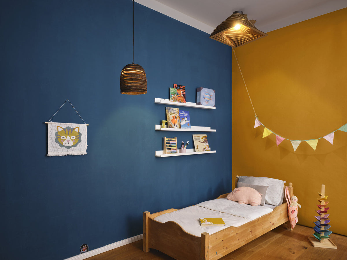 Vue d'ensemble de la chambre avec plafonnier, lit, étagères et guirlande