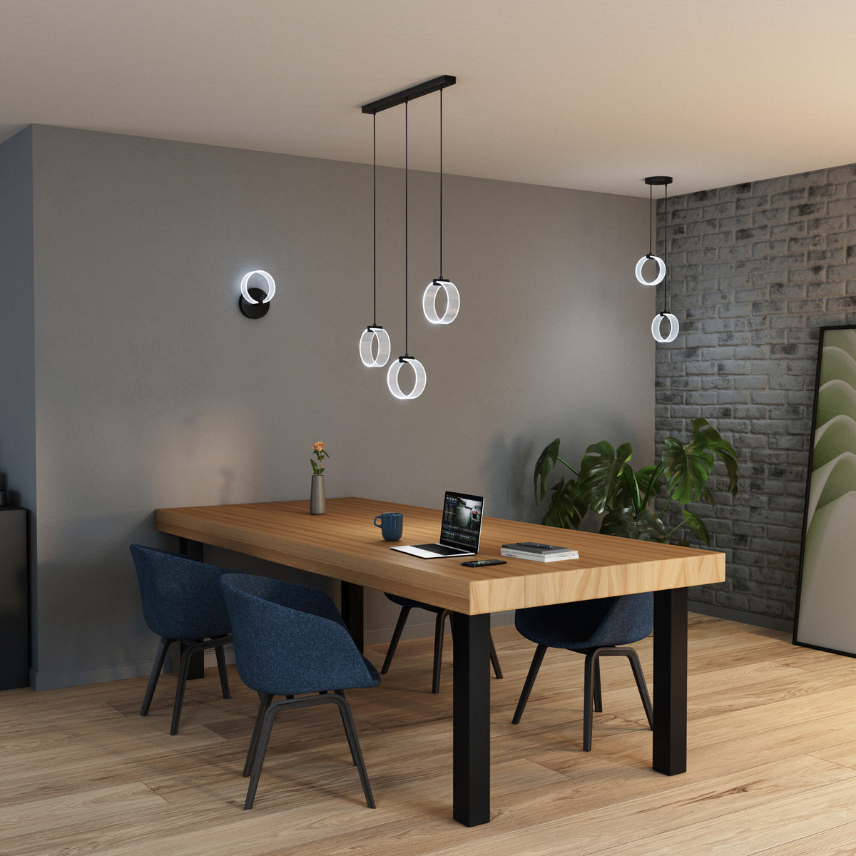 Mise en ambiance au-dessus d'une table, applique murale et suspensions circulaires allumées en blanc froid.