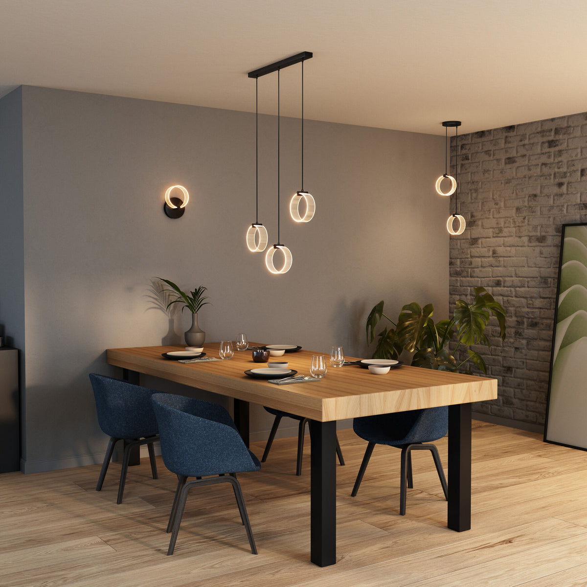 Scène de repas avec applique murale allumée, éclairage chaud et suspensions au-dessus de la table.