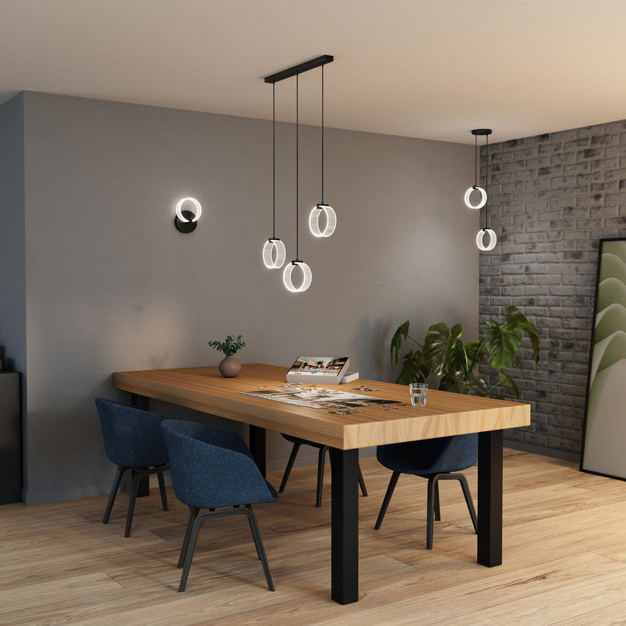 Ambiance intérieure avec applique murale et suspensions, table en bois et puzzle posé dessus.