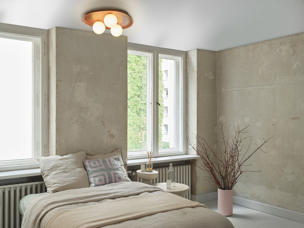 Mise en ambiance dans une chambre, plafonnier allumé au-dessus du lit