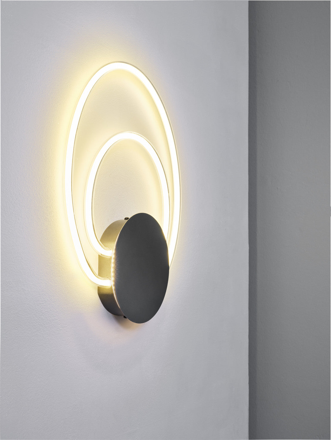 Vue rapprochée de l'applique allumée, double anneau lumineux et socle anthracite.