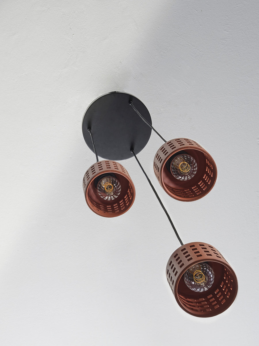 Vue du dessous du plafonnier noir et des trois suspensions avec ampoules visibles.