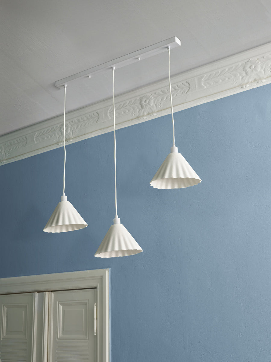 Vue de dessous du rail blanc fixé au plafond et des trois câbles de suspension.