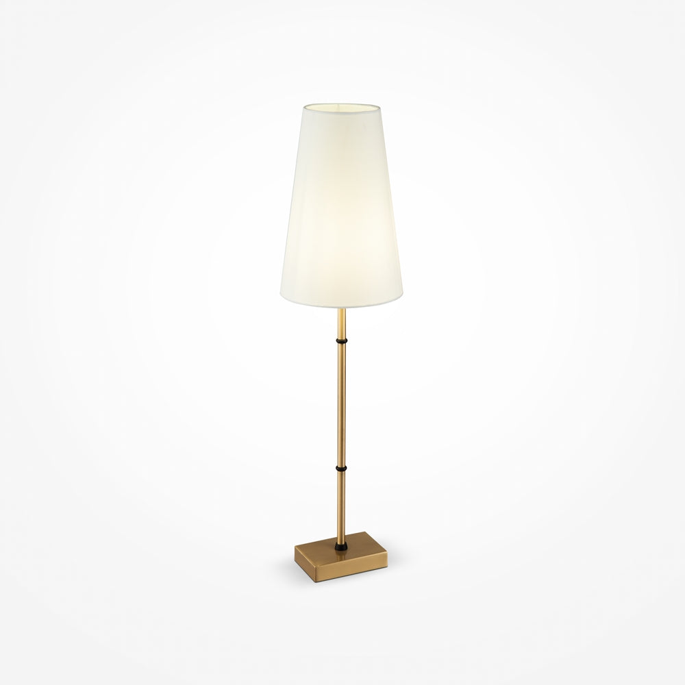 Lampe de chevet dorée sur fond blanc, abat-jour conique en tissu ivoire et tige fine