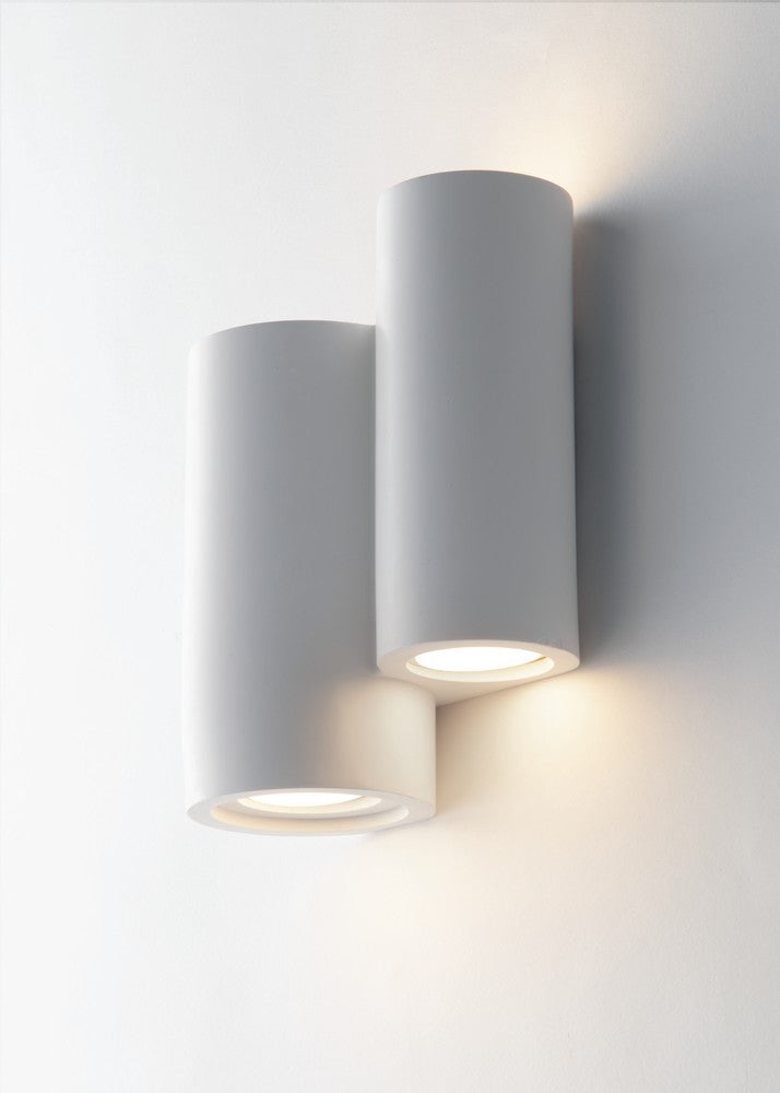 Détail rapproché de l'applique cylindrique blanche avec éclairage dirigé vers le bas