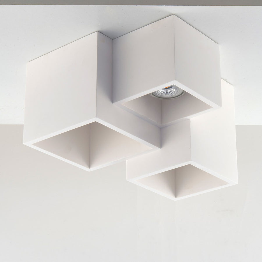 Plafonnier fixé au plafond, cubes blancs superposés dans une pièce claire