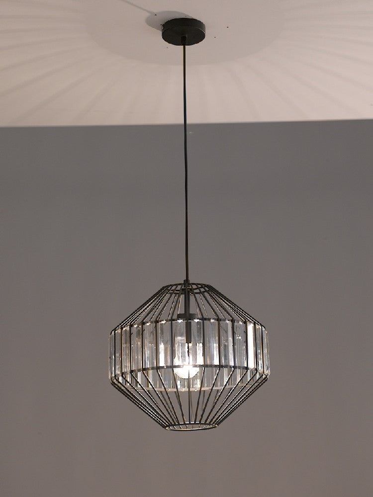 Suspension noire allumée vue de face, cage métallique et verre, mur gris en fond