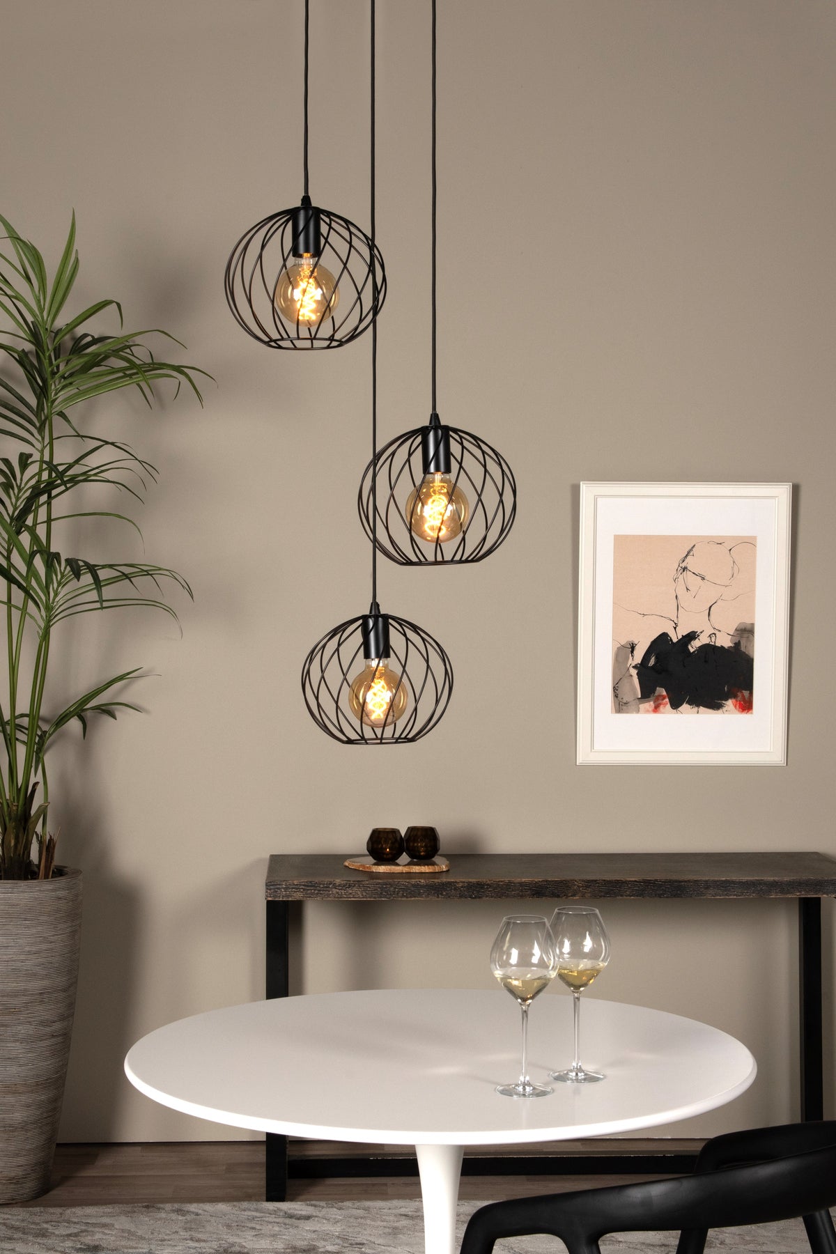 Mise en ambiance au-dessus d'une table blanche, suspension noire à trois lumières