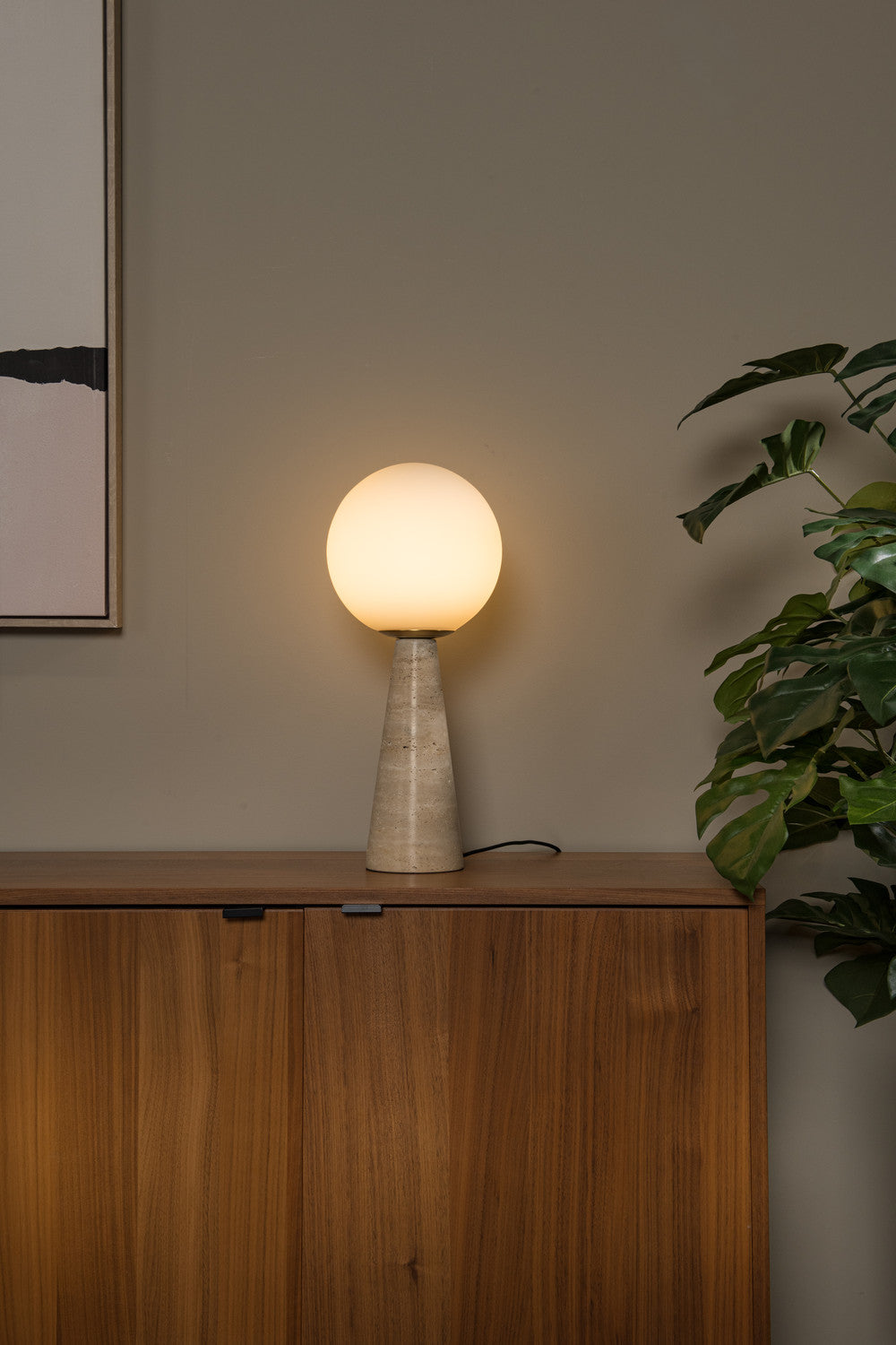Vue rapprochée du globe opale diffusant une lumière chaude sur le buffet