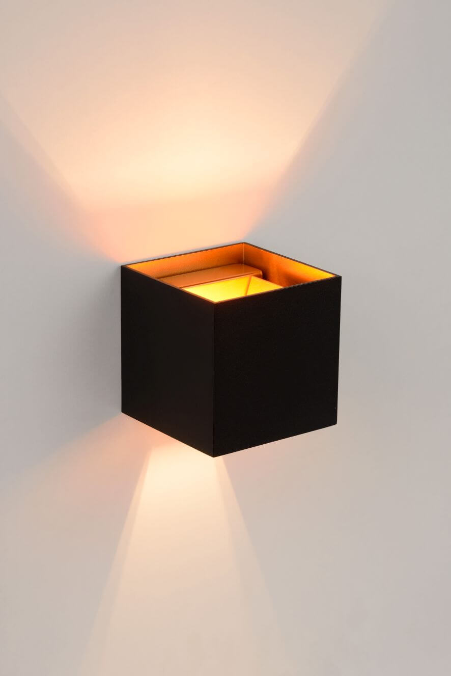 Vue en situation du cube noir diffusant une lumière chaude sur le mur