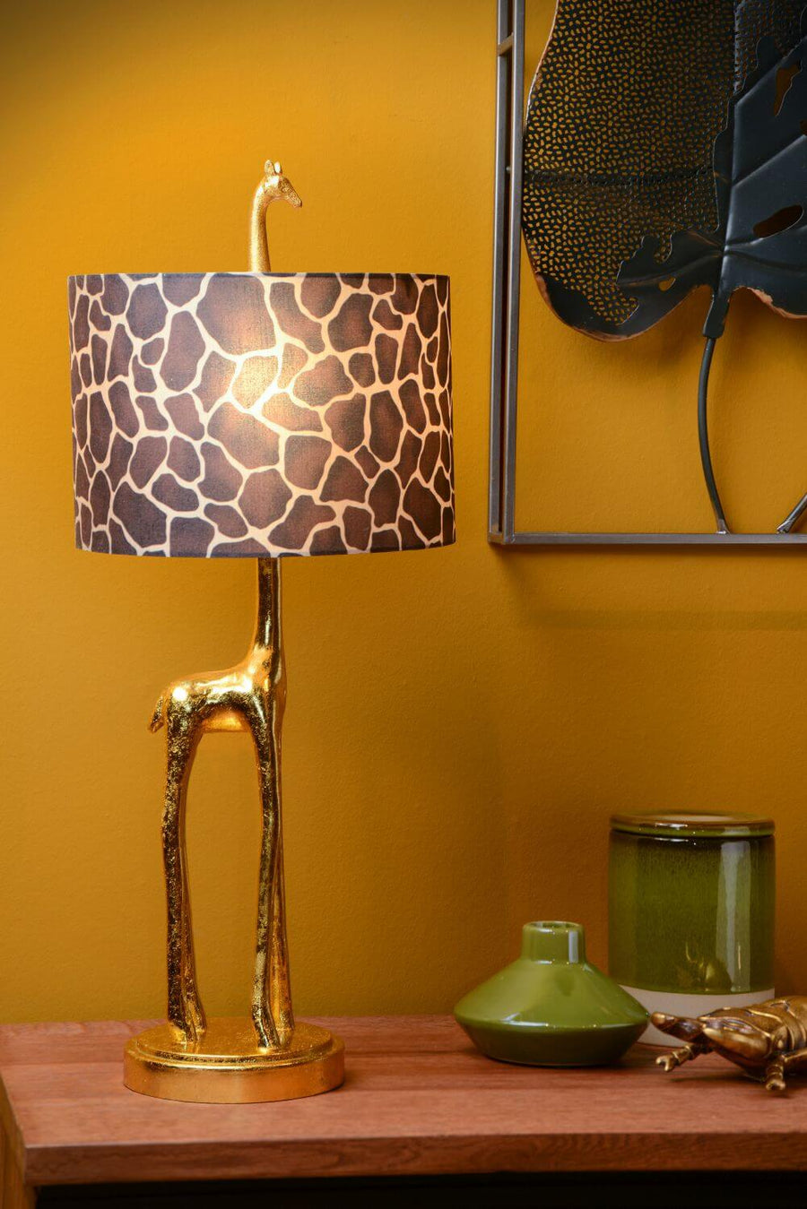 Gros plan sur la lampe girafe dorée allumée, abat-jour motif animal, vases verts