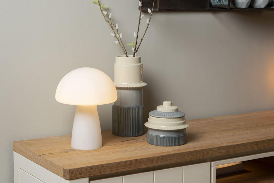 Vue rapprochée de la lampe allumée près d'un vase et d'une boîte décorative.
