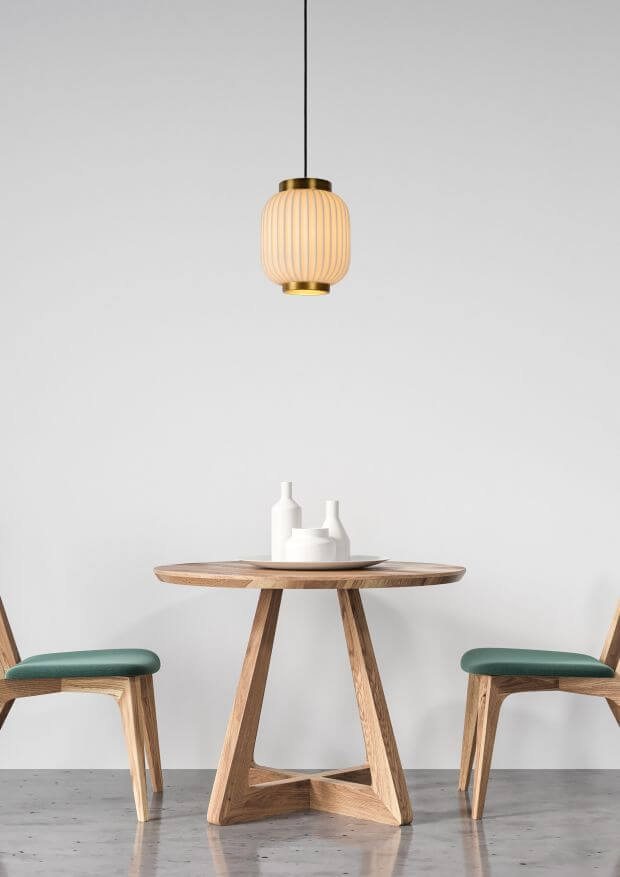 Suspension allumée au-dessus d'une table ronde en bois, ambiance intérieure claire
