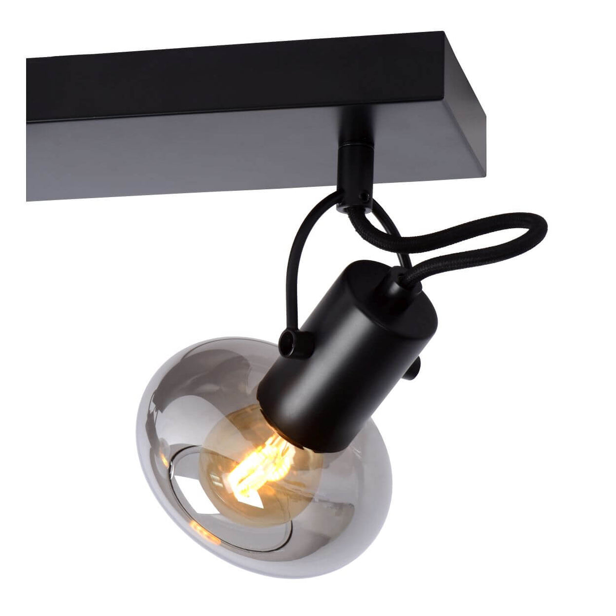 Détail d'un spot orientable, câble noir bouclé et verre fumé transparent, ampoule filament allumée.