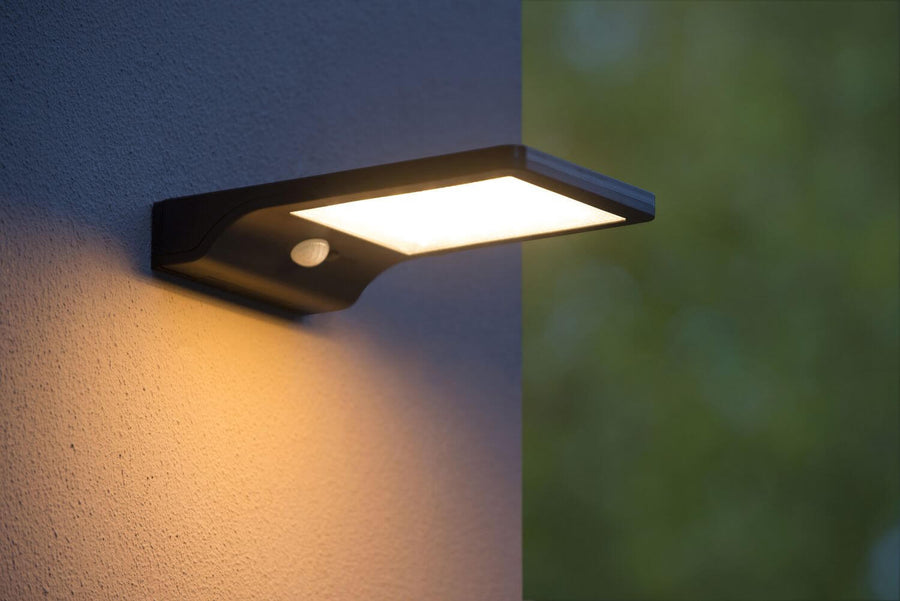 Vue rapprochée du luminaire mural allumé, diffuseur blanc et détecteur de présence visibles