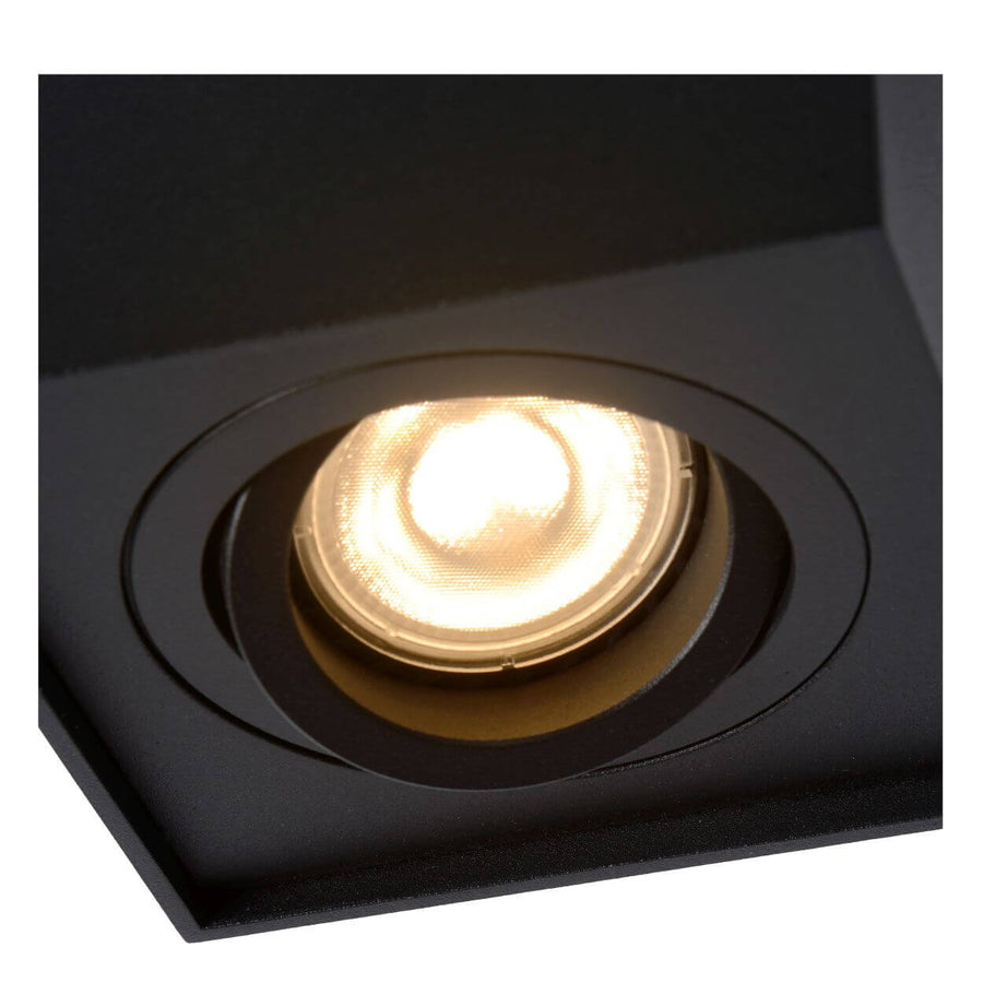 Gros plan sur l'ampoule LED encastrée et sa lentille striée dans le boîtier noir