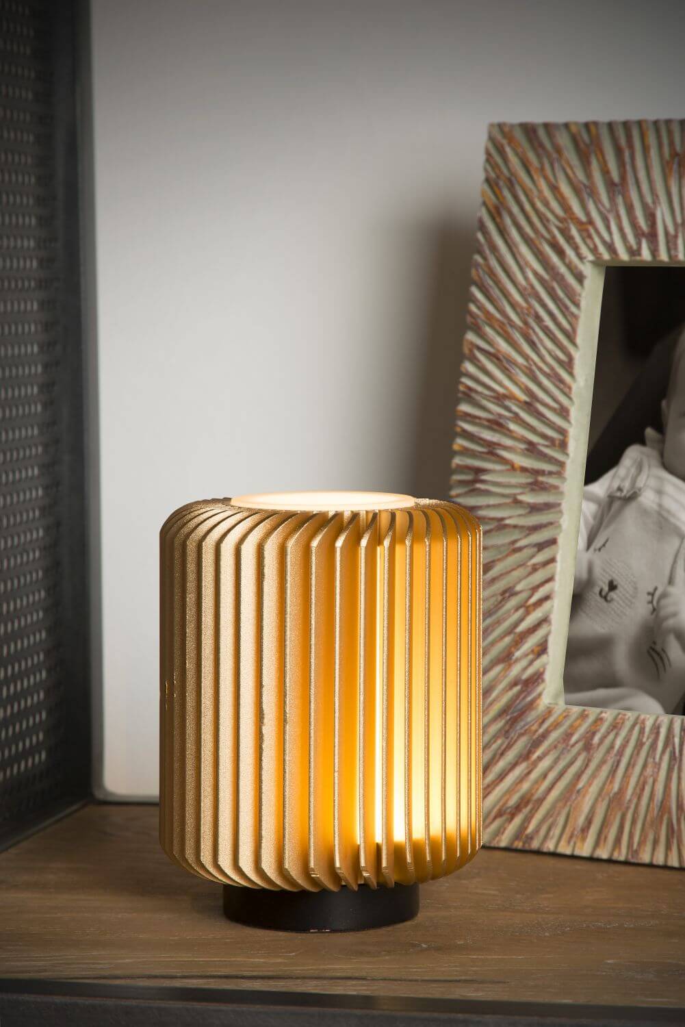 Vue rapprochée de la lampe allumée, mettant en valeur ses fines ailettes dorées.