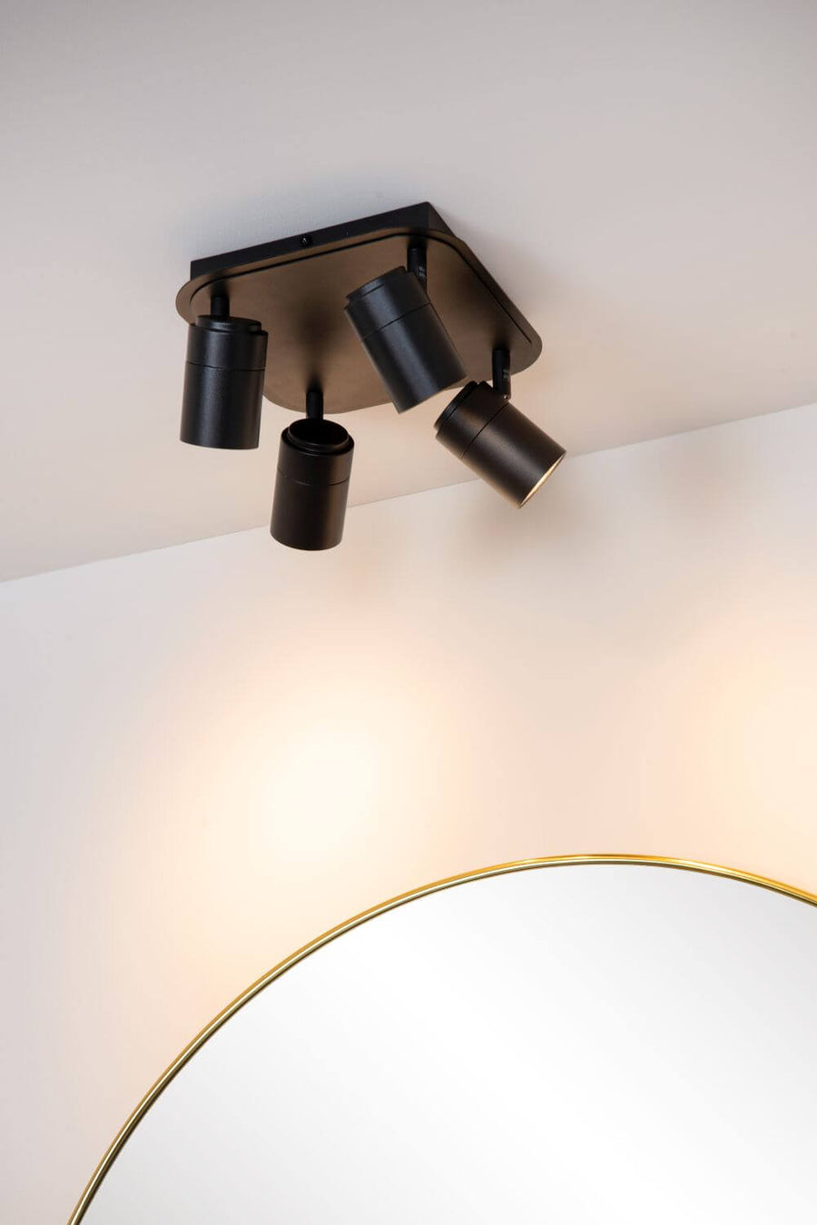 Détail de l'installation au plafond, spots noirs orientés vers le miroir doré