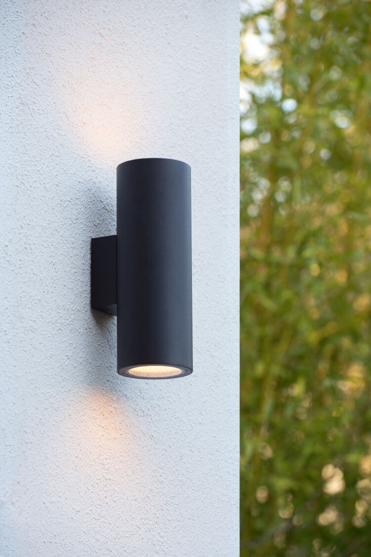 Vue rapprochée de l'applique noire sur crépi blanc, halos lumineux haut et bas