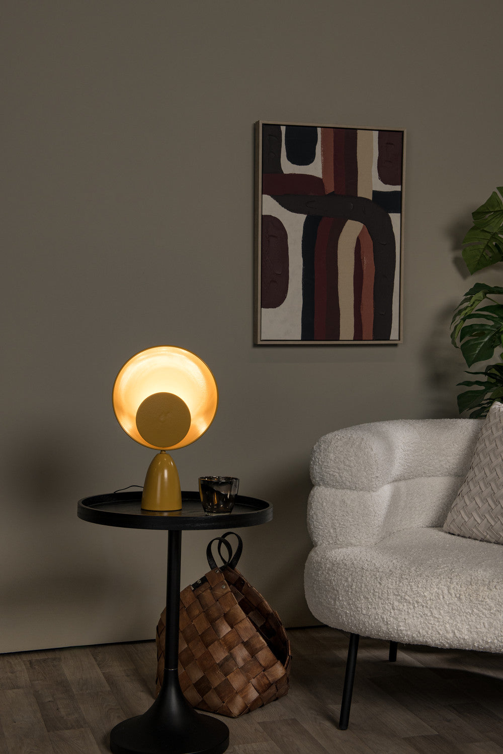 Vue rapprochée de la lampe jaune sur sa table, canapé en bouclette et plante