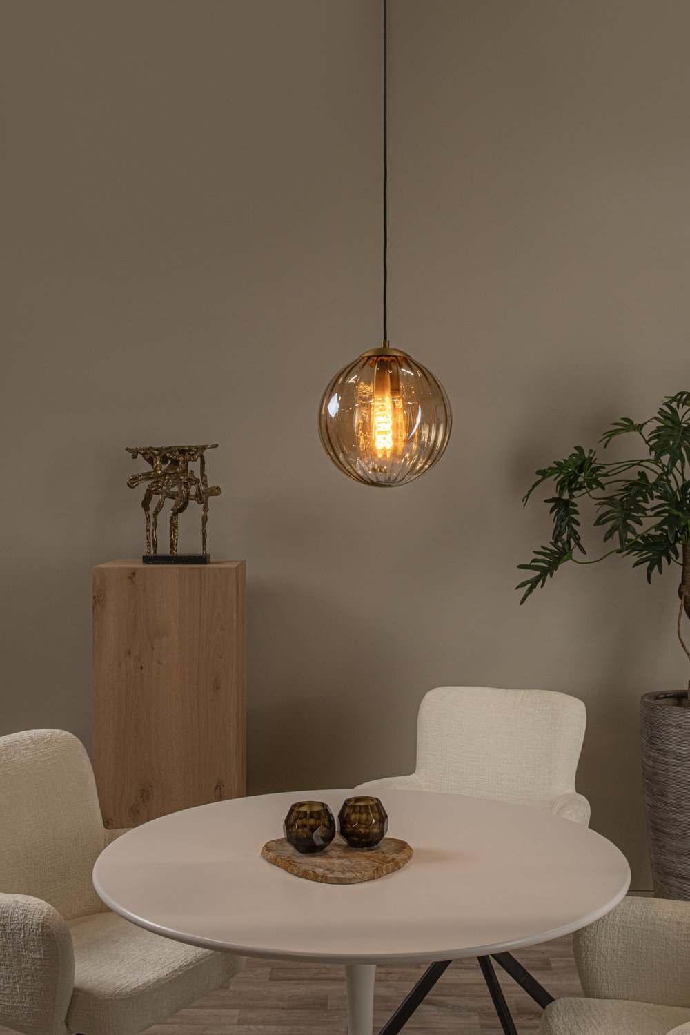 Mise en ambiance au-dessus d'une table ronde avec chaises et plantes.