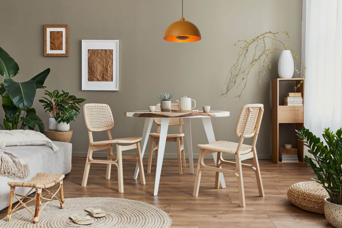 Mise en ambiance au-dessus d'une table à chaises cannées dans un intérieur clair.
