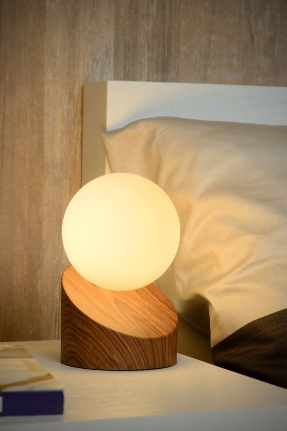 Vue rapprochée de la lampe allumée près d'un oreiller dans une chambre