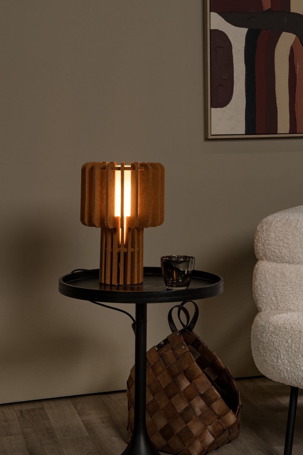 Vue rapprochée du luminaire allumé, lamelles de bois et verre fumé sur la table