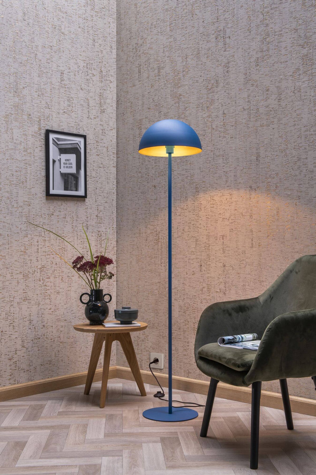 Vue d'ensemble du lampadaire bleu près d'un fauteuil vert et table basse