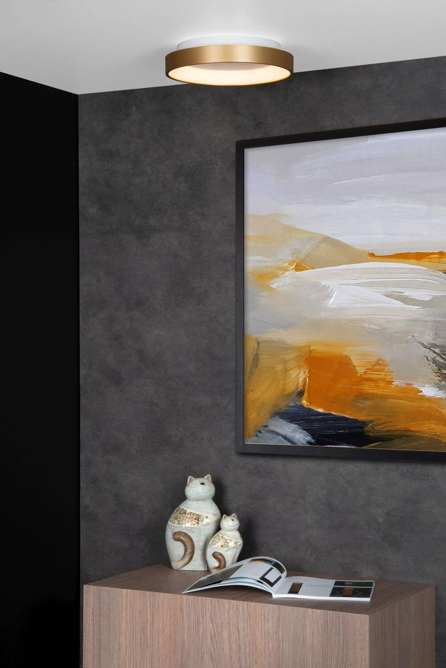 Vue rapprochée du plafonnier doré éclairé au-dessus d'un tableau abstrait