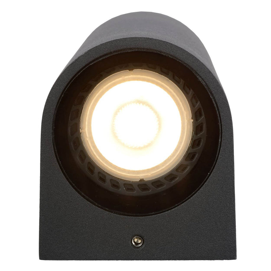 Face avant du luminaire, lentille LED allumée, vis de fixation visible en bas