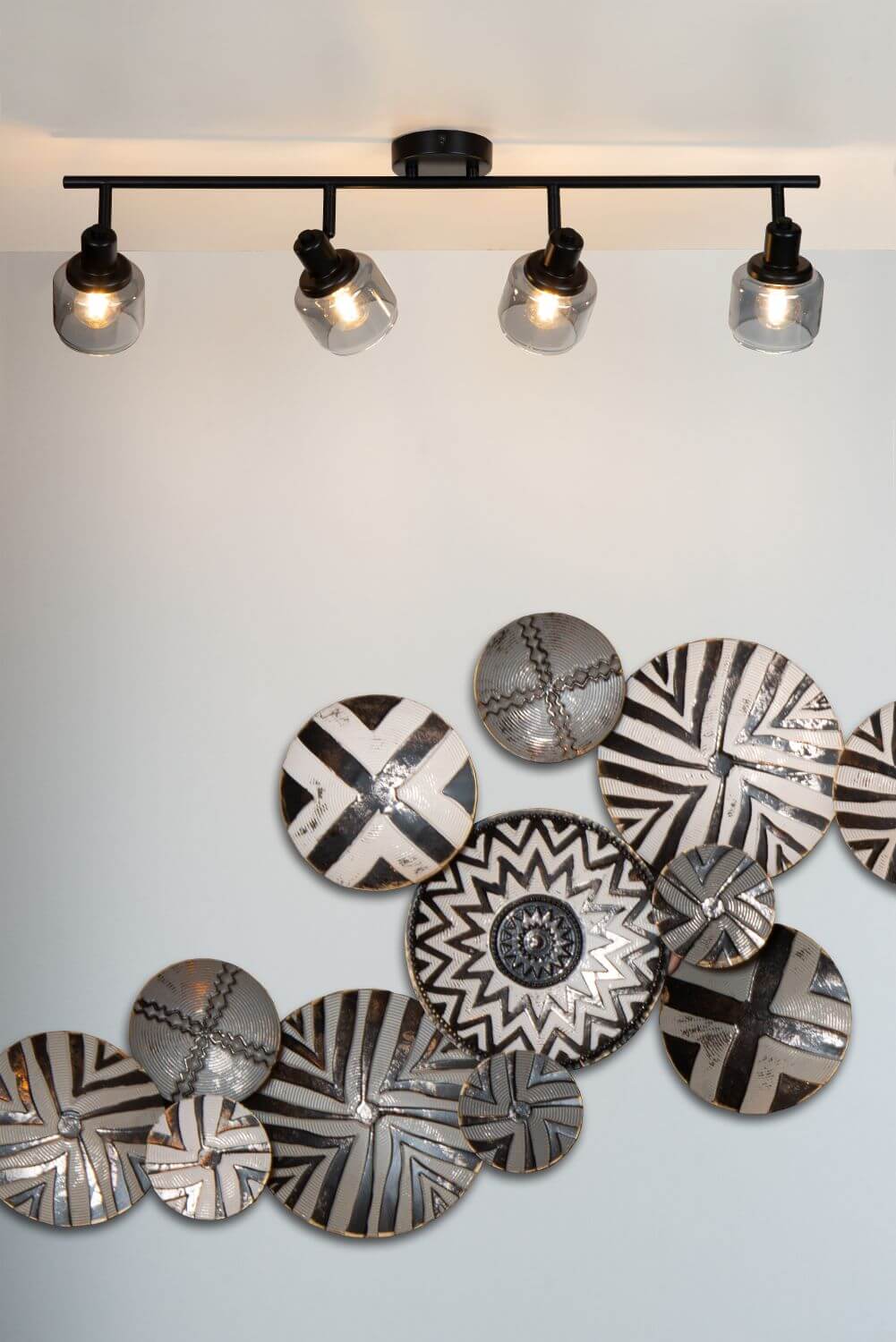 Mise en ambiance murale avec disques métalliques gravés et plafonnier allumé