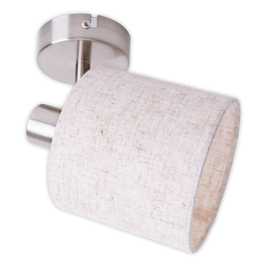 Vue rapprochée du spot mural orientable, abat-jour cylindrique en tissu beige, support métal brossé