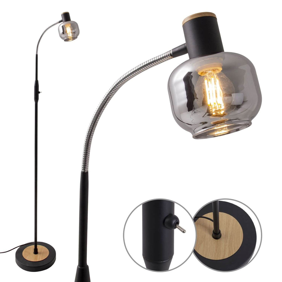 Gros plan du lampadaire allumé, abat-jour en verre fumé et détails de l'interrupteur et du socle.