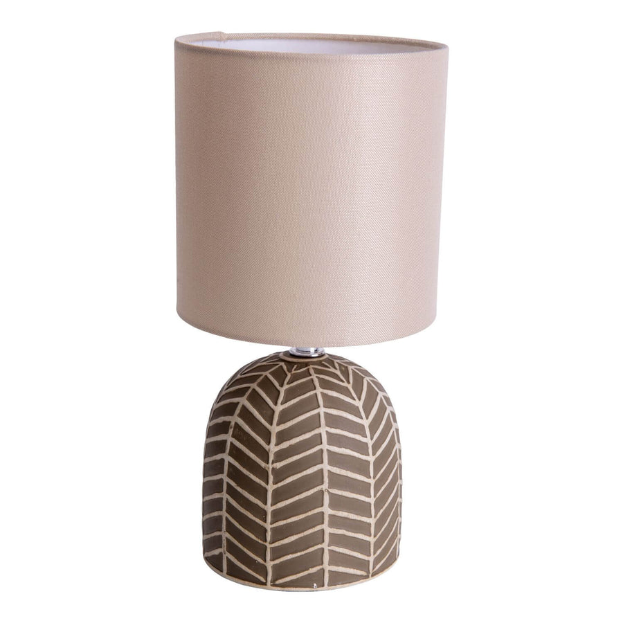 Lampe à poser vue de face, abat-jour cylindrique beige et base bombée brune motif chevrons