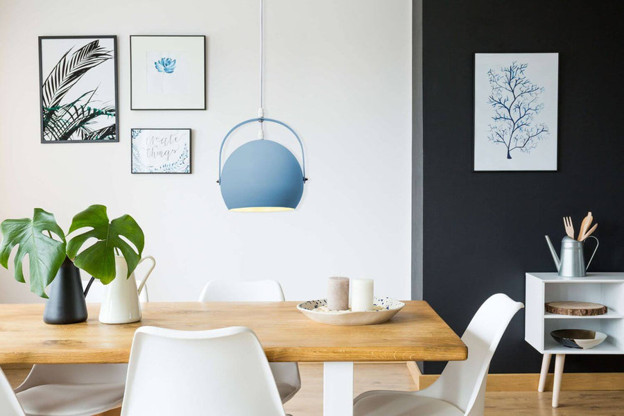 Suspension bleue installée au-dessus d'une table en bois, salle à manger lumineuse.