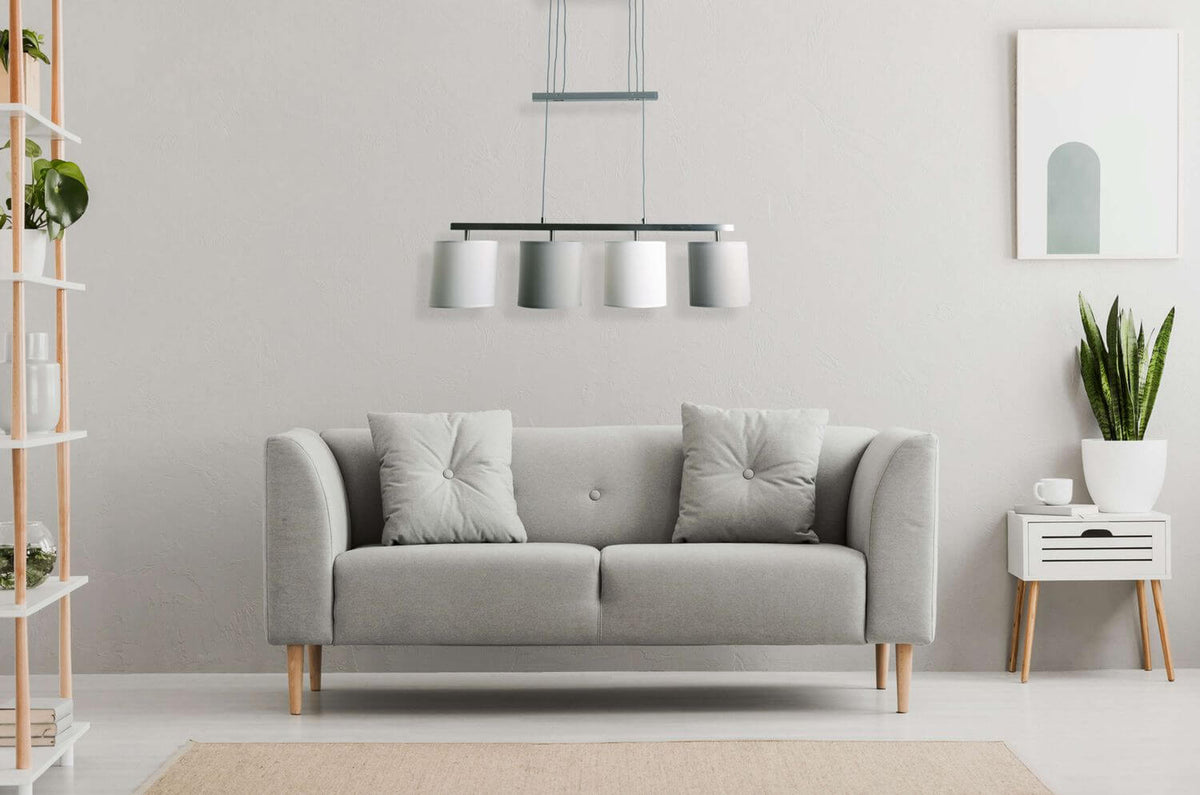 Mise en ambiance salon moderne, canapé gris et suspension alignée au-dessus du sofa