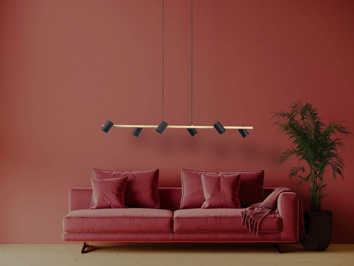 Mise en ambiance du luminaire suspendu au-dessus d'un canapé rouge dans un salon.